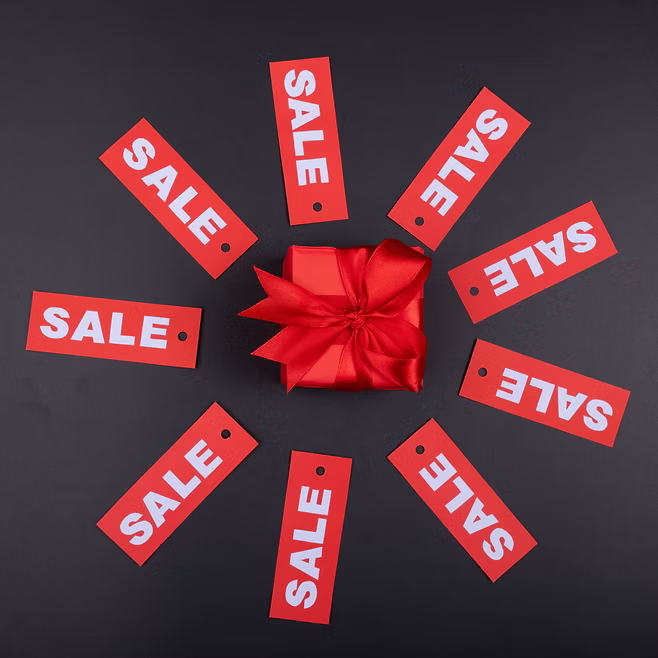 Gift box surrounded by red sale tags